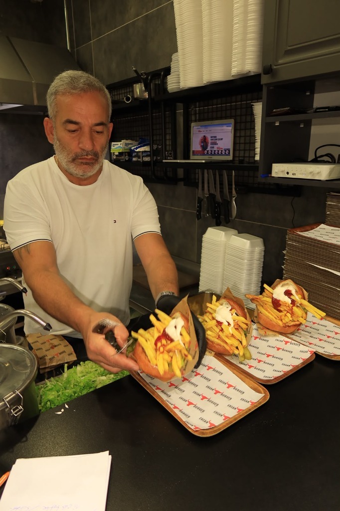 Ercan Usta tezgâhta el yapımı hamburgerleri hazırlıyor